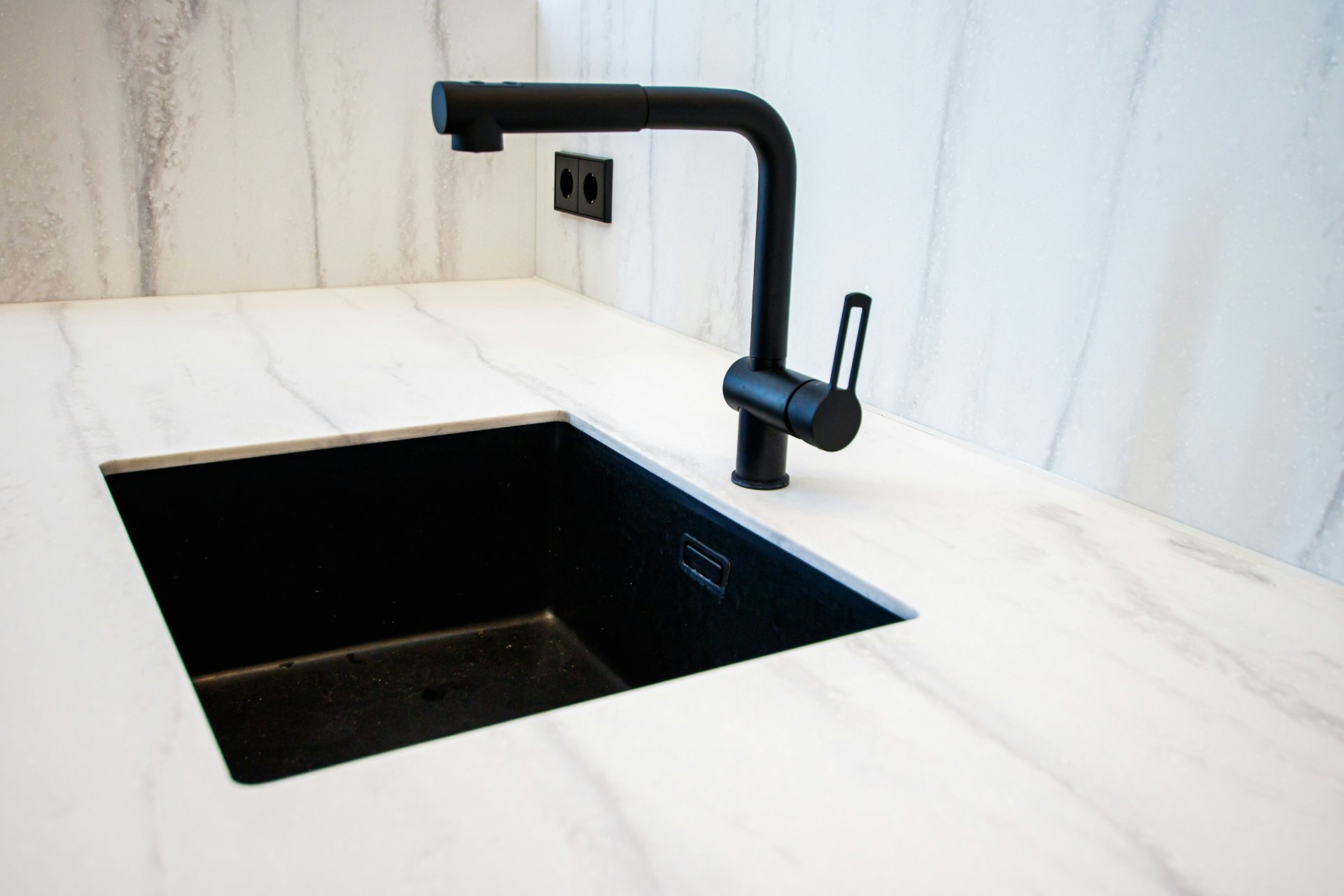 Marble countertop with an undermount black sink and matte black faucet