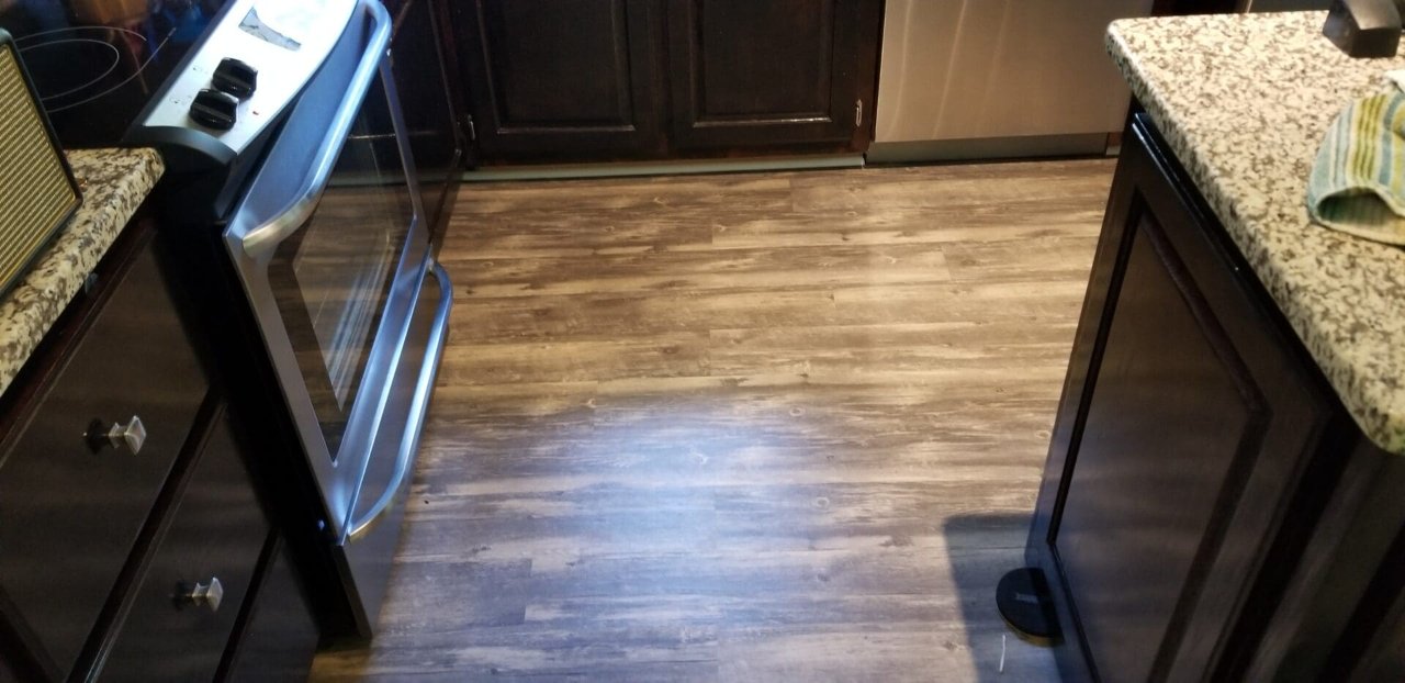 Wood-look plank running into a kitchen