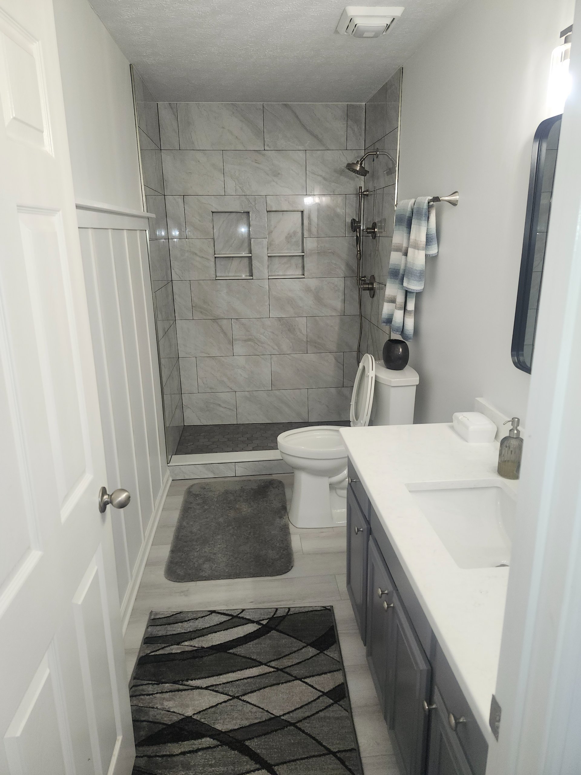 New vanity beside a tiled tub surround