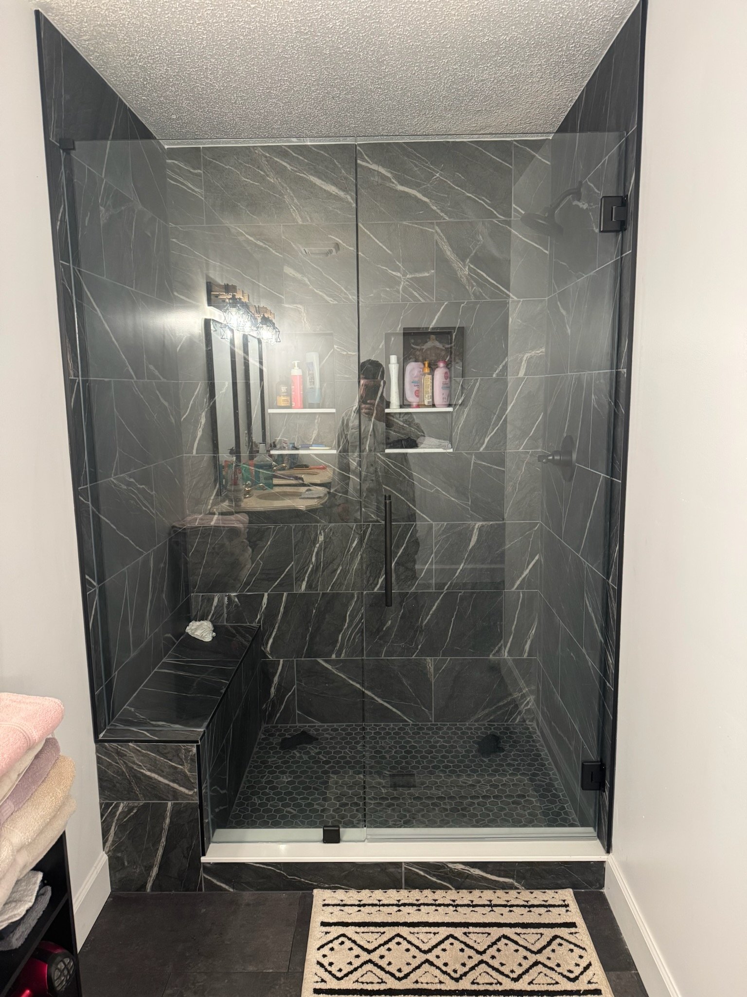 Dark marble walk-in shower with glass enclosure