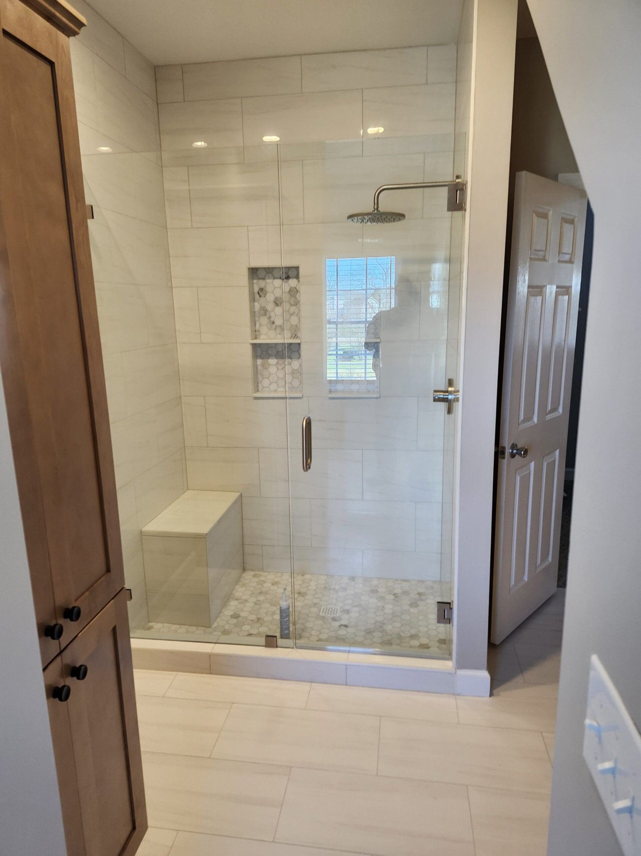 Tiled shower seen through a framed opening