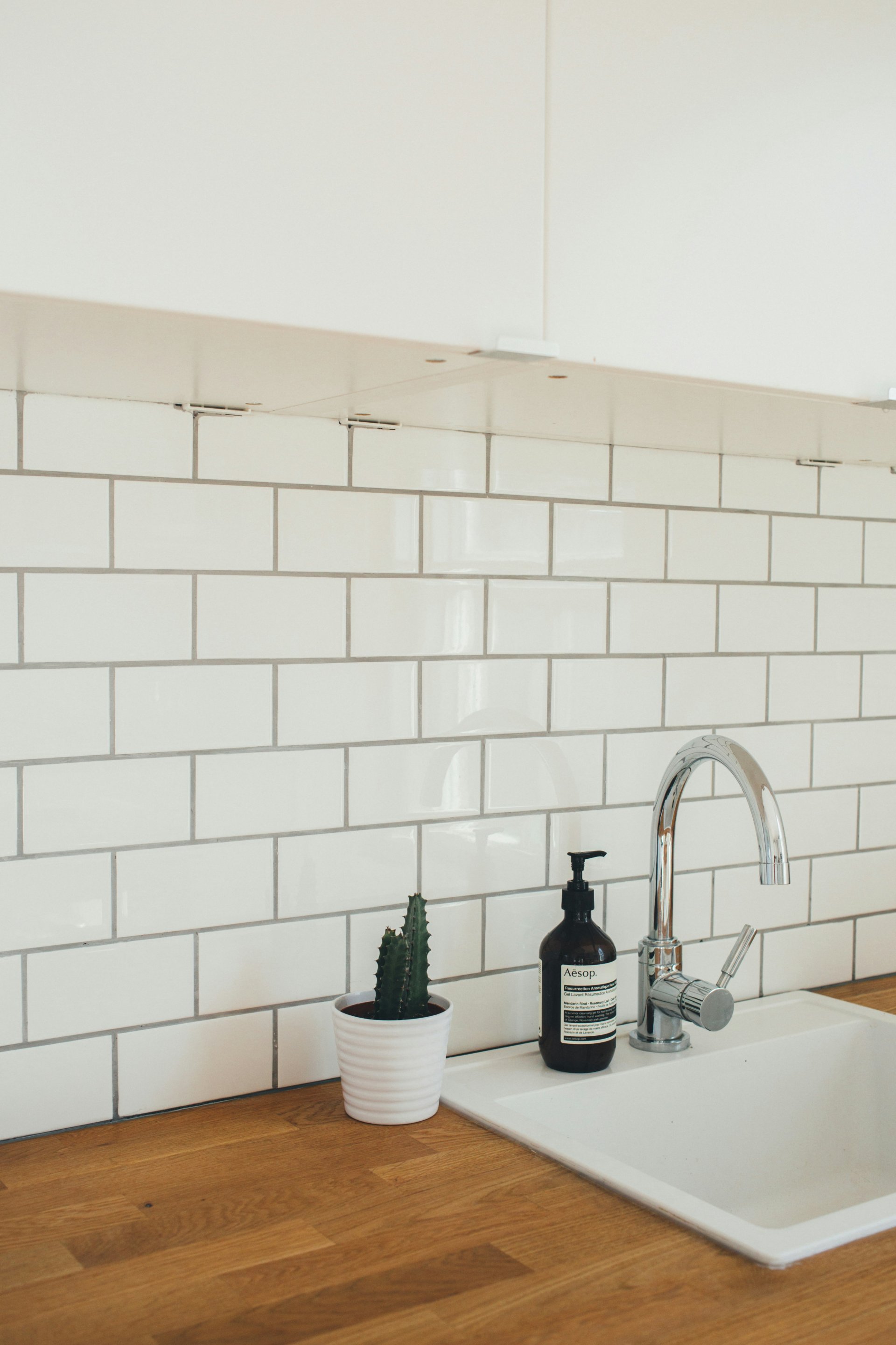 White subway tile backsplash above a kitchen sink